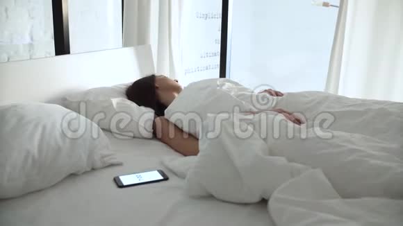 闹钟在电话里睡在床上醒来的女人视频的预览图