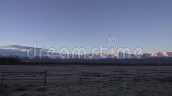 美丽的风景清晨在山上霜在草地上的前景雪峰上的黄色阳光视频的预览图