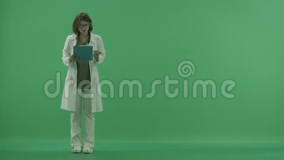 医生解释了她的记录然后用她的手在绿色屏幕上指着什么视频的预览图