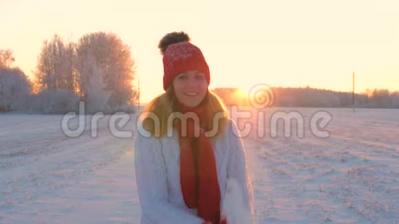 快乐的女人扔雪站在降雪中在冬天的户外跳舞视频的预览图