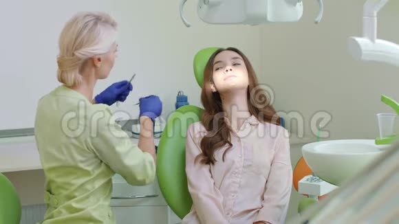 牙科办公室龋齿治疗在牙科椅上张开嘴的女人视频的预览图