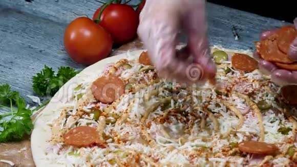 厨师烹饪腊肠披萨戴烹饪手套美食概念框架把意大利香肠放到披萨上视频的预览图