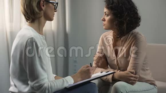 女性心理学家倾听女性患者抑郁与分手治疗视频的预览图