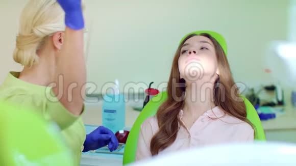 女牙医在牙科办公室钻孔病人的牙齿医生和病人视频的预览图