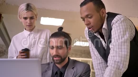 三个不同民族的工人在办公室讨论笔记本电脑的概念同事的概念沟通的概念视频的预览图