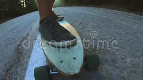特写滑板少年骑户外一个年轻人骑着长板在高速公路上森林里的米斯蒂路视频的预览图