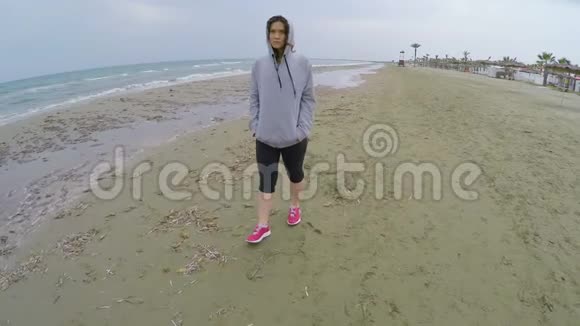 穿着运动服的悲伤女人在海滩上散步想着男朋友视频的预览图
