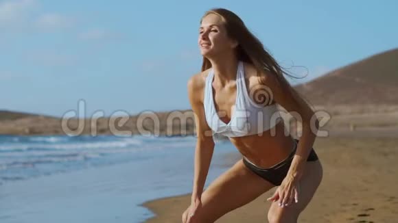 年轻的女强人穿着运动服在码头上做几何练习跳蹲户外健身锻炼流动人口视频的预览图