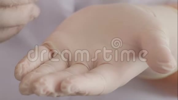 在白色手套中特写女性的手挤压透明的硅掌美容或医学的主题视频的预览图