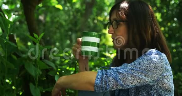 在花园里喝咖啡的成熟女人视频的预览图