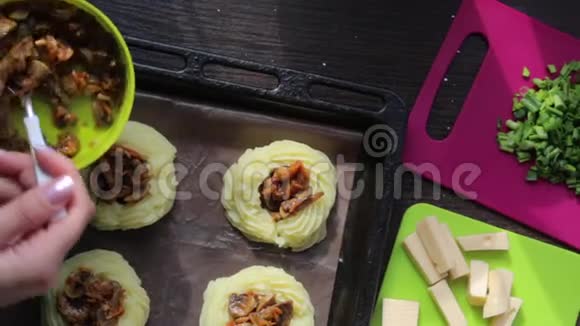 那个女人用蘑菇把土豆泥圈装满了锅旁边的其他食材做菜饭视频的预览图