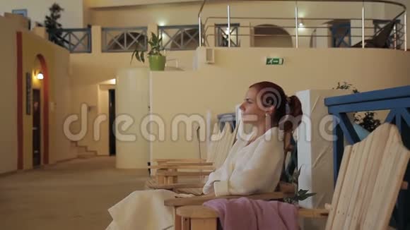 在豪华水疗沙龙里坐在舒适的木制扶手椅上的女人的肖像视频的预览图