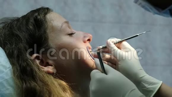 去看牙医牙齿矫正医生为一名年轻女子安装铁支架视频的预览图