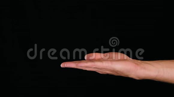 闭上空的雄性手掌在黑色的背景上握着什么视频的预览图