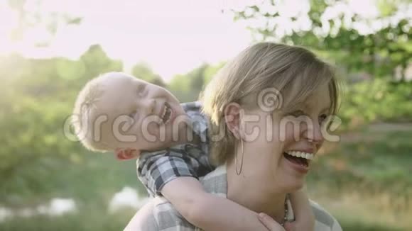 年轻漂亮的妈妈和儿子一起玩夏季公园慢动作全高清视频的预览图
