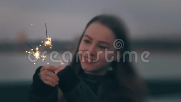 年轻的白种人女人在户外日落时与星火嬉戏视频的预览图