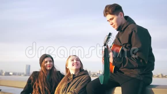 几个快乐的朋友在日落时分用吉他在户外唱歌视频的预览图