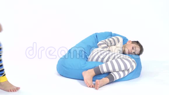 小男孩睡在靠近熟睡的弟弟的豆袋里视频的预览图