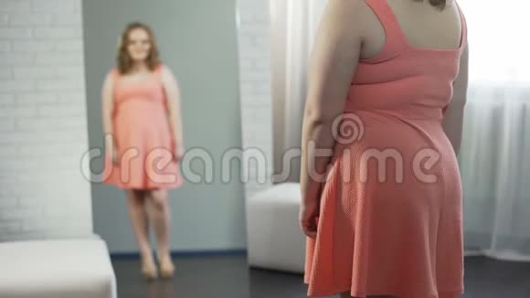 超重女孩在镜子前梳妆打扮对外表满意视频的预览图