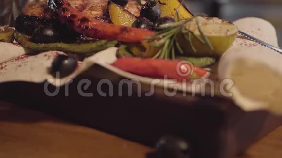 烤三文鱼与草药橄榄辣椒和柠檬躺在皮塔近距离准备和服务视频的预览图