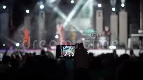 手拿唱片摄像机智能手机现场音乐会表演拍照音乐乐队剪影跳舞的人视频的预览图