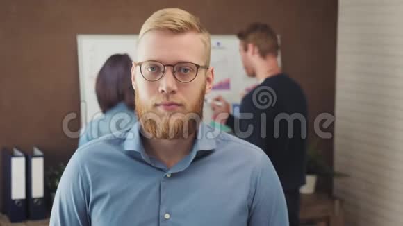 一位年轻商人站在一间时髦办公室的肖像视频的预览图