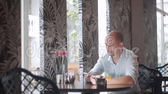 男人喝橙汁用智能手机视频的预览图
