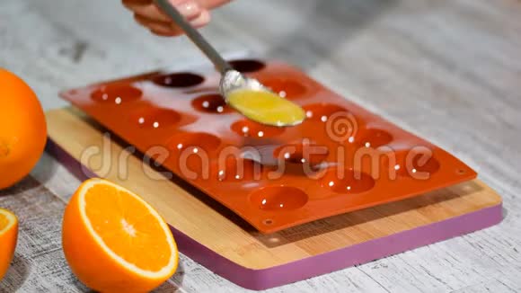 在硅胶模具中浇注橙色果冻视频的预览图