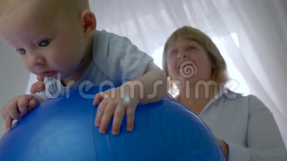 小病人躺在一个充气蓝球上背景是专业治疗师室内背光视频的预览图