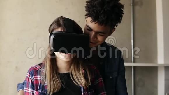 可爱的幸福夫妇女孩正在经历虚拟现实游戏由她的男朋友指导她视频的预览图
