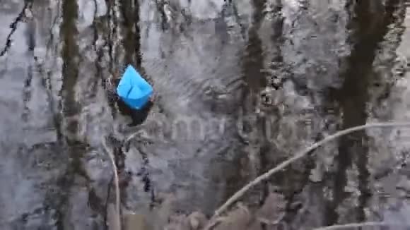 秋天公园里蓝色的小纸船在透明的河流中飘荡视频的预览图