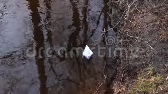小白纸船漂浮在秋天公园清澈的河流上视频的预览图