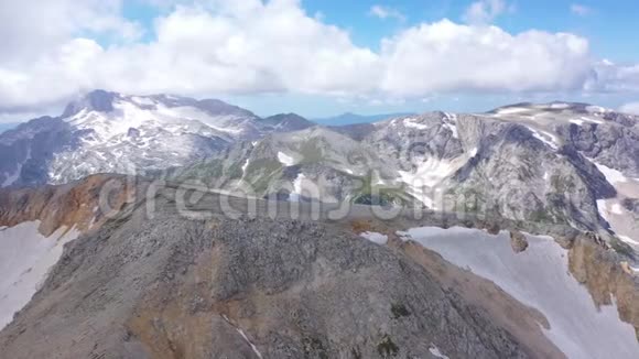 在岩石悬崖冰川和雪峰上拍摄的山脊的空中拍摄令人惊叹的山景视频的预览图