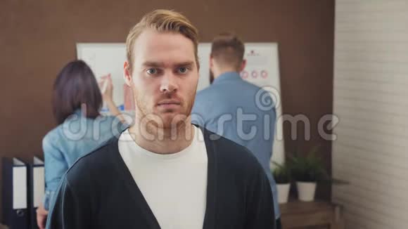 一位年轻商人站在一间时髦办公室的肖像视频的预览图