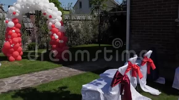 婚礼拱门由红白气球制成婚礼仪式绿色草坪视频的预览图