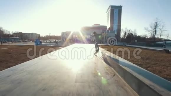 滑板运动员在日落时在户外的赛道上玩花样视频的预览图