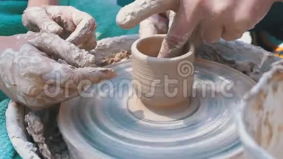 男人和女人陶工的手在陶工车轮上用粘土工作视频的预览图