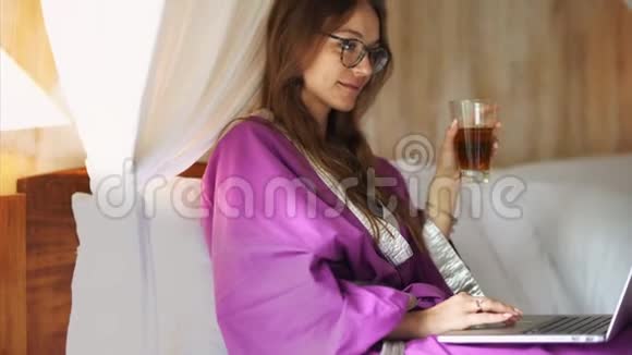 穿着浴袍的漂亮年轻女子在网上聊天视频的预览图