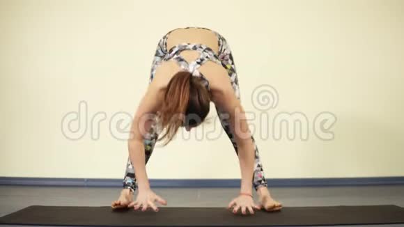 年轻有魅力的女人当进入瑜伽体式中的一种时试图达到平衡并放置全身的重量视频的预览图