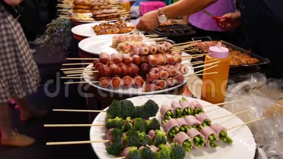 泰国传统亚洲夜市美食市场烧烤肉丸和其他异国风味的美味小吃视频的预览图
