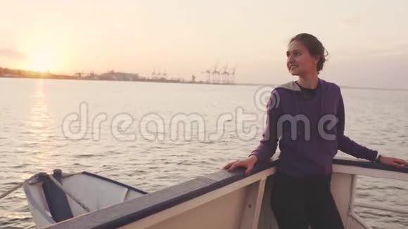 日落或日出时乘船旅行的年轻女子视频的预览图