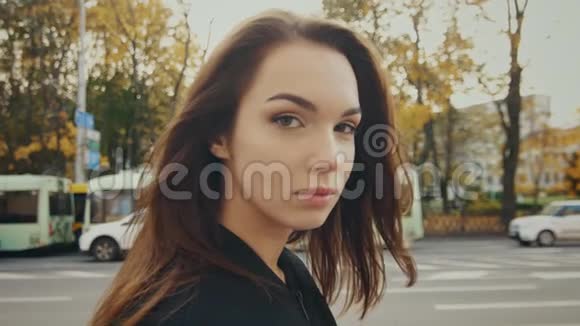 美丽的女孩走在秋天的街道上在城市中缓慢行走的模特视频的预览图