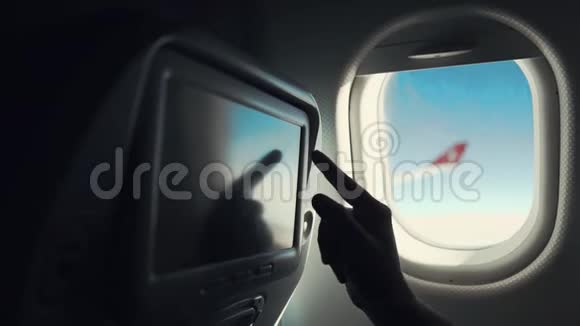 男乘客正在机场客舱座位上触摸显示器手举特写视频的预览图