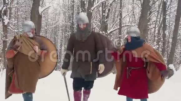 中世纪的法兰克人爱尔兰人穿着盔甲的维京勇士手持剑盾在冬林中行走视频的预览图
