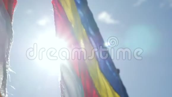 在太阳升起的光线中在风中摇曳的佛教祈祷旗特写慢动作镜头视频的预览图