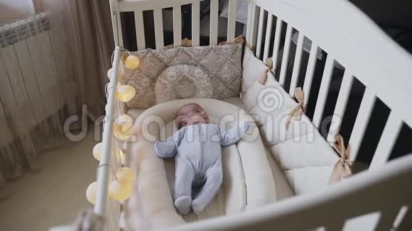 卧室里一个婴儿床上的新生婴儿正试图入睡可爱的3个月大的婴儿躺在床上小男孩视频的预览图