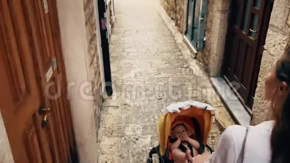 母亲和婴儿带着婴儿车在黑山老城散步视频的预览图