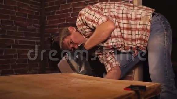 成年男子在工作间使用电动工具打磨木板视频的预览图