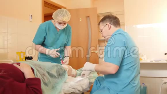 为膝盖做的医疗手术医生和护士用注射器将病人膝盖的液体排出并关闭视频的预览图