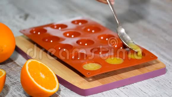 在硅胶模具中浇注橙色果冻视频的预览图